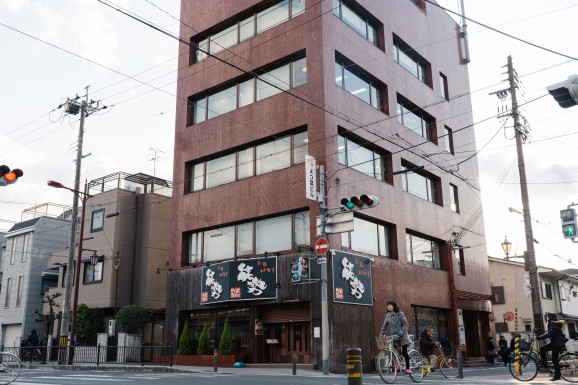（関西よつ葉連絡会の事務局と（株）ひこばえの事務所がある、茨木市内の自社ビル。１階の焼肉レストラン「美味(みー)肉屋(とはうす)能勢(のせ)」では、自社農場で育てた牛の肉を提供している）